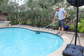 pool cleaning contractor filtering dirt out of pool