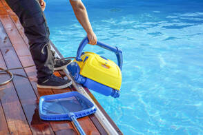 pool cleaning contractor insterting pool filter cleaning machine 